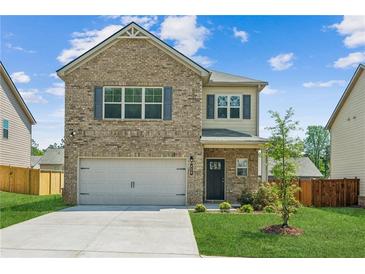Charming two-story brick home featuring an attached garage and a well-manicured lawn at 814 Lakehaven Ln, Loganville, GA 30052