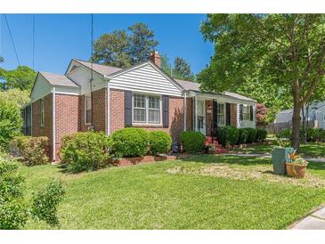 Charming brick home featuring well-manicured lawn and mature landscaping at 1325 East Forrest Ave, East Point, GA 30344