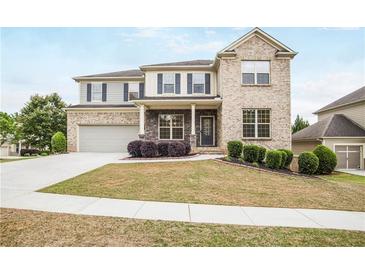 Charming two-story home with a well-manicured lawn and a mix of brick and siding at 3570 Terrasol Sw Trl, Lilburn, GA 30047