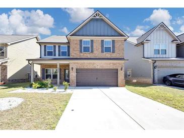 Charming two-story brick home with a welcoming front porch and a well-manicured lawn at 2375 Walker Dr, Hampton, GA 30228