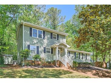 Charming two-story home with a manicured front yard and mature trees providing ample shade at 1718 Country Park Way, Lawrenceville, GA 30043