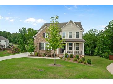 Charming two-story home with a brick and siding exterior, a well-manicured lawn, and a welcoming front porch at 13 Oakside Nw Ct, Cartersville, GA 30121
