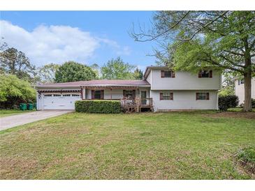 Charming two-story home with a well-maintained front yard, attached garage, and covered front porch at 1608 Drakes Dr, Jonesboro, GA 30236
