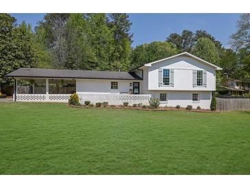 Charming white brick home with well-manicured lawn and covered carport at 3935 Manor House Dr, Marietta, GA 30062