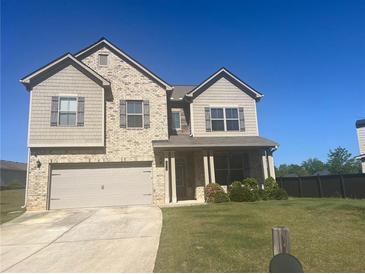Charming two-story home with a two-car garage, and a well-maintained lawn at 375 Madison Grace Ave, Mcdonough, GA 30252
