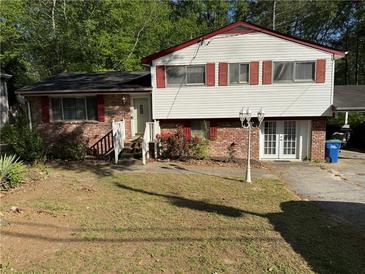 Charming home featuring a well-maintained lawn, brick accents, and a two-story design at 6695 Cedar Hurst Trl, Atlanta, GA 30349