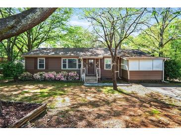 Charming single-story home with a welcoming front yard, flowerbeds and mature shade trees at 1400 Hidden Circle Dr, Sugar Hill, GA 30518
