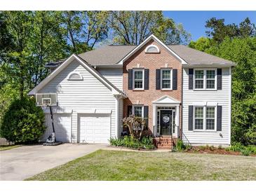 Charming two-story home with a brick facade, black shutters, and a well-maintained front yard at 5108 Staplehurst Ln, Woodstock, GA 30189