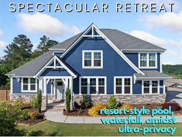 Beautiful two-story blue home featuring stone accents, white trim and lush landscaping at 2111 Harmony Dr, Canton, GA 30115