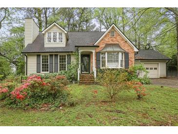 Charming home with dormer windows, black shutters, brick accent and front yard with flowering plants at 172 Forest Nw Ln, Marietta, GA 30064