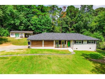 Charming single-story home featuring a bright green front door and meticulously manicured lawn at 5950 Central Church Rd, Douglasville, GA 30135