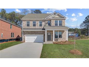 Charming two-story brick home with attached garage and manicured lawn at 612 Leafy Branch Way, Mcdonough, GA 30253