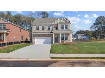 Charming two-story brick home featuring a two-car garage and manicured front lawn at 612 Leafy Branch Way, Mcdonough, GA 30253