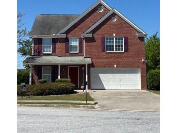 Charming two-story brick home with a well-manicured front yard, a driveway, and an attached two-car garage at 2763 Storybook Ct, Grayson, GA 30017