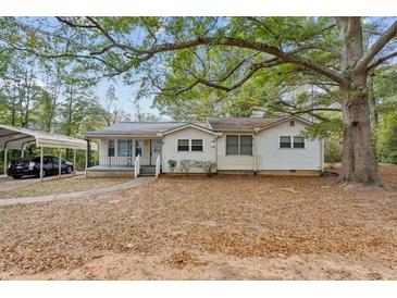 Charming single-story home with vinyl siding and a spacious, tree-filled front yard at 3024 Bob Cox Rd, Marietta, GA 30064