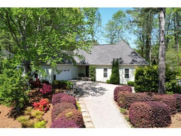 Charming one-story home featuring a lush landscaped yard, mature trees, and a spacious driveway at 11050 Linbrook Ln, Duluth, GA 30097
