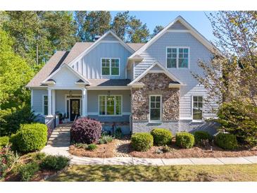 Charming home featuring stone accents, a covered porch, and manicured landscaping at 1438 Sutters Pond Nw Dr, Kennesaw, GA 30152