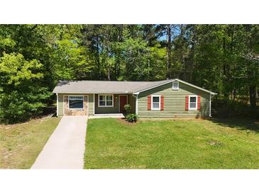 Charming green home with red door and shutters, stone facade, and a well-manicured lawn at 530 Bell Se Rd, Conyers, GA 30094