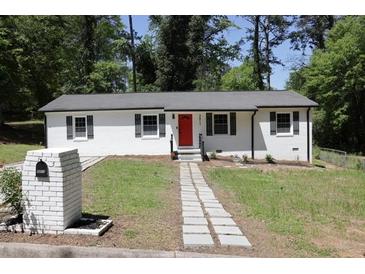 Charming ranch home featuring a freshly painted exterior, a red front door, and a well-maintained front lawn at 3811 Crosby Nw Dr, Atlanta, GA 30331