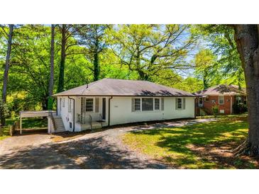 Charming single-story home featuring a white exterior, covered parking, and a lush green lawn at 754 Pinehill Se Dr, Smyrna, GA 30080