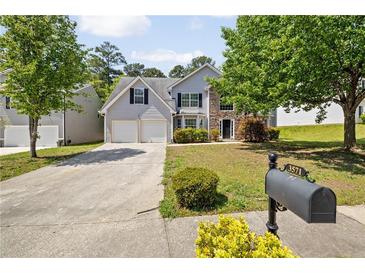 Charming two-story home with a well-manicured lawn, two-car garage, and stone accents at 3571 Oakshire Se Way, Atlanta, GA 30354