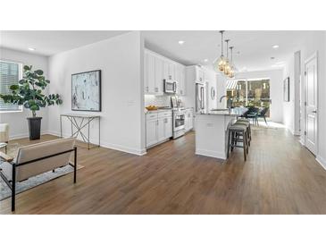 Bright, open kitchen with white cabinets, stainless steel appliances, and a large island with bar seating at 392 Pratt Dr # 2013, Atlanta, GA 30315