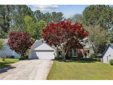 Charming single-Gathering home with a well-maintained lawn, mature trees, and inviting curb appeal at 4805 Diggers Way, Sugar Hill, GA 30518
