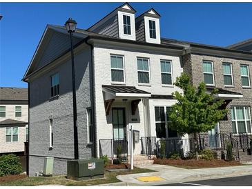 Charming two-story townhome with painted brick, dormer windows and manicured landscaping at 1329 Bennett Creek Ovlk, Suwanee, GA 30024