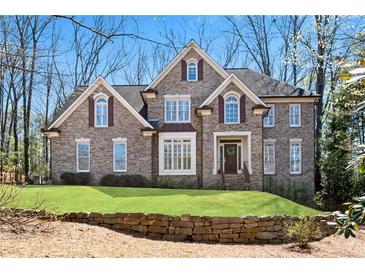 Charming brick home with manicured lawn and beautiful stone retaining wall at 1548 Valley Reserve Nw Ct, Kennesaw, GA 30152