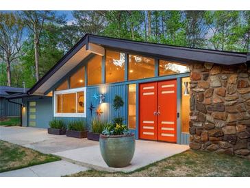 A unique home with a modern design featuring a stone accent wall and vibrant orange double-door entry at 2895 Dunnington Cir, Atlanta, GA 30341