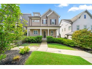 Charming home featuring a welcoming front porch, manicured lawn, and lush landscaping at 52 Lath House Ln, Marietta, GA 30066