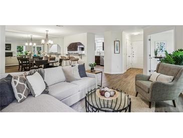 Bright open-concept living room with contemporary furnishings, flowing seamlessly into the dining and kitchen areas at 908 Hollyfax Cir, Sandy Springs, GA 30328