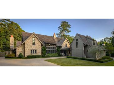Stunning stone home featuring a shake roof, manicured lawn, and a circular driveway surrounded by mature trees at 2979 Ridgewood Nw Rd, Atlanta, GA 30327