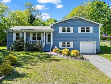 Charming blue two-story home with white trim, manicured lawn, and a welcoming front porch at 363 Arnold Mill Rd, Woodstock, GA 30188
