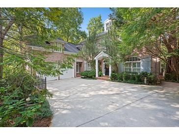 Beautiful brick home featuring an attached two-car garage and a spacious driveway surrounded by mature trees at 4470 Crestwicke Pointe, Atlanta, GA 30319