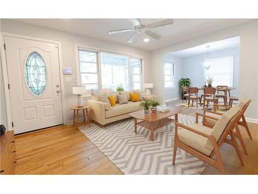 Bright living room features a ceiling fan, hardwood floors, and a seamless transition to the dining area at 145 Holly Nw Rd, Atlanta, GA 30314