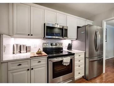 Bright kitchen features stainless steel appliances, white cabinets and stone countertops at 505 Bainbridge Dr, Atlanta, GA 30327