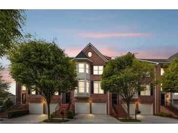 Charming brick townhome with manicured front yard and inviting entrance, perfect for upscale living at 1299 Dunwoody Cv, Atlanta, GA 30338