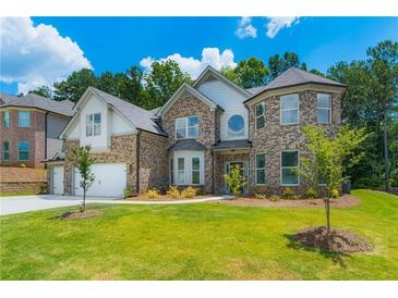 Charming two-story brick home featuring a well-manicured lawn and two-car garage at 1821 Silver Crest Way, Hoschton, GA 30548