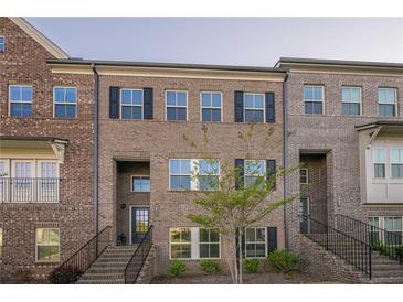 Brick townhome featuring black shutters and a welcoming front entrance at 3877 Via Cima Ln, Suwanee, GA 30024