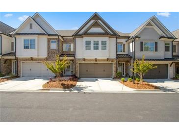 Charming townhomes featuring brick and siding exteriors, complemented by well-maintained landscaping at 605 Stone Field Nw Run, Marietta, GA 30060