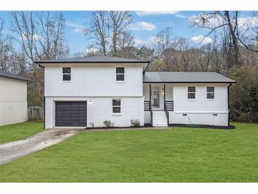 Charming two-story home with a freshly painted white exterior and well-manicured lawn at 9148 Homewood Dr, Riverdale, GA 30274