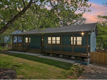 Charming blue home featuring a spacious front porch and a well-manicured lawn at twilight at 1596 Pontiac Se Pl, Atlanta, GA 30315