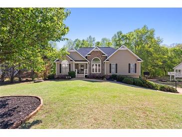Charming home boasts a well-manicured lawn, complemented by mature trees and a stone facade entrance at 840 Whitby Dr, Douglasville, GA 30134