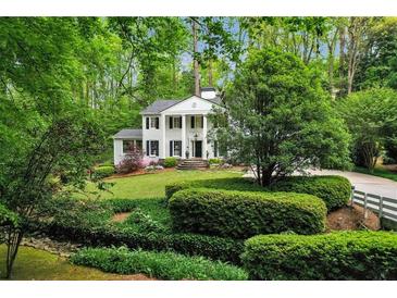 Beautiful two-story home with black shutters, white columns, and lush green landscaping at 2562 Red Valley Rd, Atlanta, GA 30305
