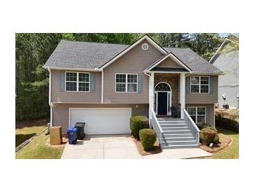 Charming two-story home with a well-manicured lawn and a welcoming front porch with gray-painted stairs at 4175 Round Stone Dr, Snellville, GA 30039