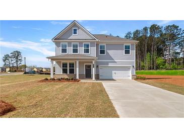 Charming two-story home featuring a covered front porch and an attached two-car garage at 540 Teversham Dr, Mcdonough, GA 30253
