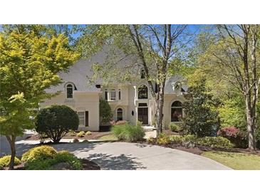 Elegant two-story home featuring a circular driveway, lush landscaping and well-maintained lawn at 960 Tiverton Ln, Alpharetta, GA 30022