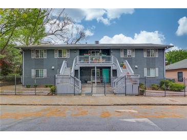 Charming apartment building with inviting turquoise doors, fenced front yard, and beautiful landscaping at 210 Sampson Ne St # 8, Atlanta, GA 30312