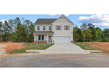 Charming two-story home with a two-car garage and a well-manicured lawn at 576 Teversham Dr, Mcdonough, GA 30253